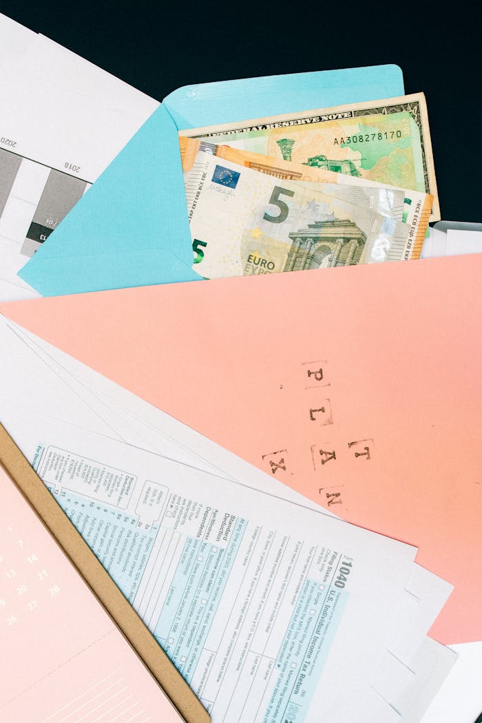 Close-up of colorful envelopes containing Euro notes and various papers, symbolizing financial planning.
